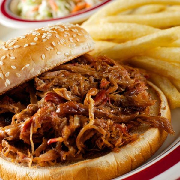 Rib City's pulled pork sandwich with a side of golden french fries and coleslaw.